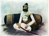 Maharana Fateh Singh (1849–1930) ruled Mewar for 46 years from 1884 to 1930, with Udaipur as capital, and resided in the City Palace, Udaipur.<br/><br/>

He was born on 16 December 1849 at Shivrati, son of Maharaj Dal Singh of the Shivrati branch of Mewar dynasty, a descendant of the fourth son, Arjun Singh, of the Rana Sangram Singh II (1710-1734). First he was adopted by his elder brother, Gaj Singh who had no heir, subsequently Maharana Sajjan Singh of Udaipur, who too had no heir, adopted him, he eventually became the Maharaja of Udaipur in 1884.<br/><br/>

He was the only Maharaja to not attend the Delhi Durbar, both of 1903 and 1911. Then in 1921, when the Prince of Wales, Edward VIII, son of Queen Mary, visited Udaipur, he refused to receive him citing illness and instead sent his son. This act brought him into conflict with the British Raj, and thereafter, under the garb of ignoring a social unrest in Mewar, on 28 July 1921, his powers were curtailed and he was formally deposed, he was however allowed to retain his title, though effective power was handed to his son and heir, Bhupal Singh.